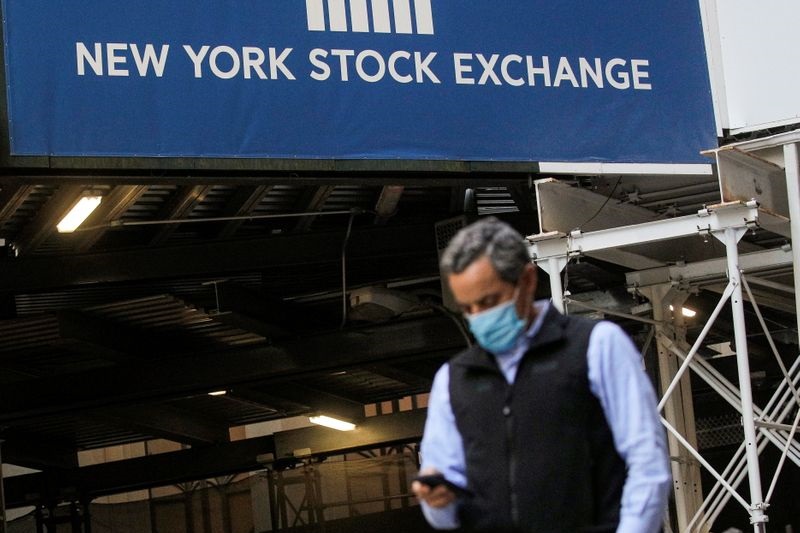 A New York Stock Exchange employee uses his phone on Wall St. outside the NYSE in New York