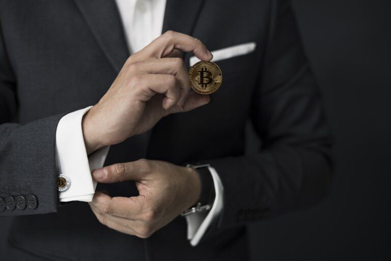 man in business suit holding bitcoin 768x512 1 - مورگان استنلی 6.5 میلیون سهم بیت کوین در گری اسکیل خریداری کرد